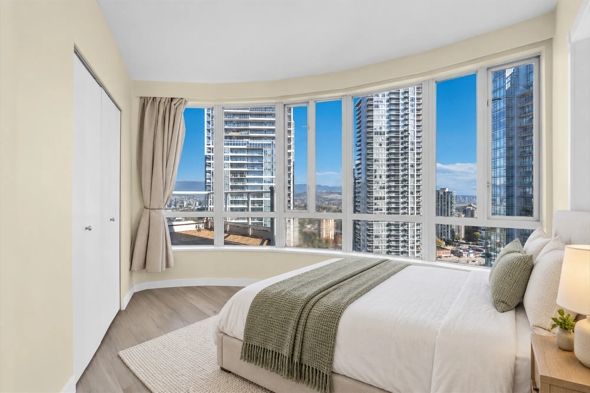 The same frame virtually staged: a bed with a green throw, a night table and lamp, a rug