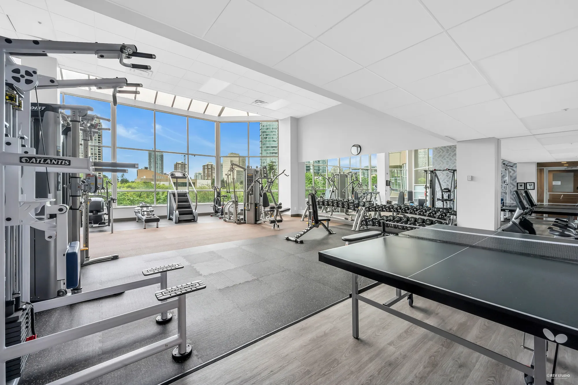 The exercise room: weight machines, treadmills, a ping-pong table, windows onto the towers